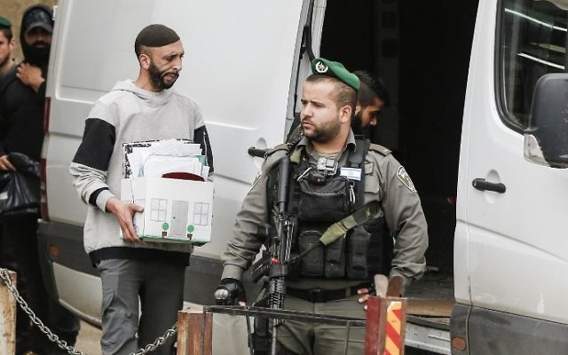 Les forces de l'ordre israéliennes dans le village d'al-Ram en Cisjordanie, durant la fermeture des bureaux aui auraient été utilisés par l'AP pour suivre les transactions immobilières entre Palestiniens et juifs, le 14 mars 2017. (Crédit : AFP PHOTO/Ahmad Gharabli)