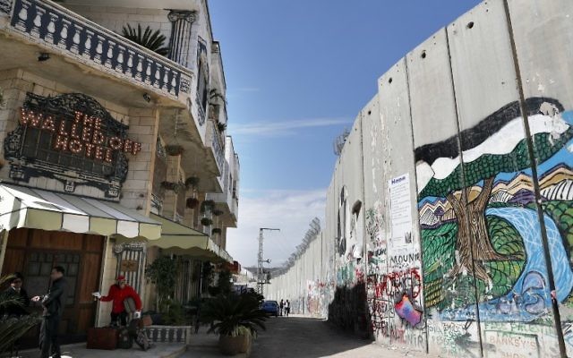 L'hôtel de l'artiste britannique Bansky face au mur de séparation dans la ville de Bethléem en Cisjordanie, le 15 mars 2017. (Crédit : Thomas Coex/AFP)
