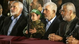 Yahya Sinwar, 2e à droite, nouveau chef du Hamas à Gaza, et Ismail Haniyeh, à gauche, près du fils de Mazen Foqaha, cadre terroriste du groupe, pendant ses funérailles, à Gaza Ville, le 27 mars 2017. (Crédit : Mahmud Hams/AFP)