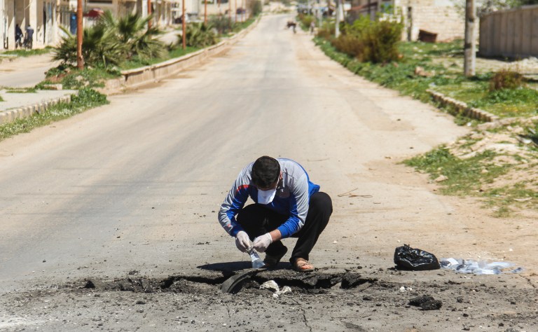Un Syrien collecte des échantillons sur le site d'une attaque au gaz toxique à Khan Cheikhoun, dans la province syrienne d'Idleb, le 5 avril 2017. (Crédit : Omar Haj Kadour/AFP)