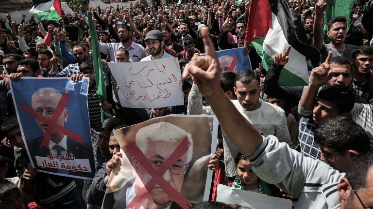 Des partisans gazaouis du Hamas pendant une manifestation contre le président de l'Autorité palestinienne Mahmmud Abbas, au centre, et son Premier ministre Rami Hamdallah à Khan Yunis, le 14 avril 2017. (Crédit : Said Khatib/AFP)