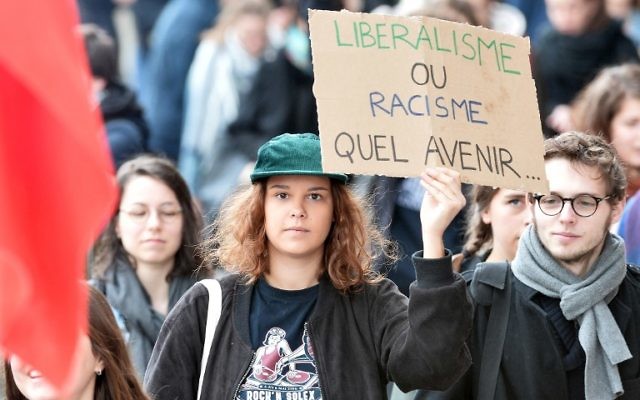 Une manifestante tenant une pancarte qui dit « le libéralisme ou le racisme. Quel avenir ...» lors d'une manifestation pour dénoncer les résultats du premier tour de l'élection présidentielle française le 27 avril 2017 à Rennes, en France (Crédit : AFP PHOTO / JEAN-FRANCOIS MONIER)
