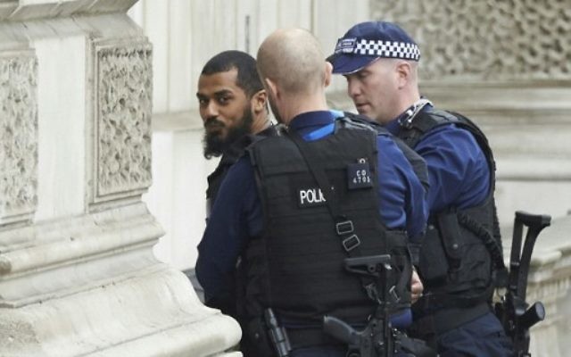 Des officiers britanniques armés ont arrêté un homme en possession de couteau près du Parlement, dans le centre de Londres, le 27 avril 2017. (Crédit : Niklas Halle'n/AFP)