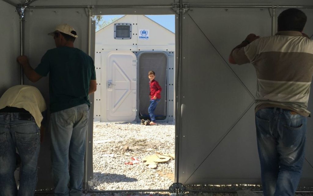 Des hommes assemblent 'Better Shelter', ces refuges temporaires financés par Ikea et utilisés dans les zones touchées par les catastrophes naturelles (Autorisation : Musée d'art de Tel Aviv)