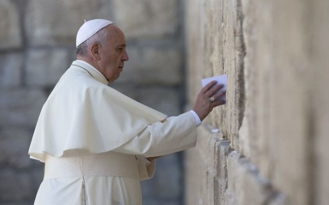 Le Pape François place une note  de prière au mur Occidental, le lieu de prière le plus saint du Judaïsme, dans la vieille Ville de Jérusalem le 26 mai 2014 (Crédit  : Thomas Coex/AFP)