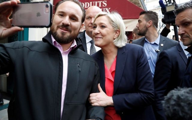 Marine Le Pen avec un de ses partisans à la sortie de son QG de campagne, au jour du second tour de l'élection présidentielle française, le 7 mai 2017. (Crédit : François Guillot/AFP)