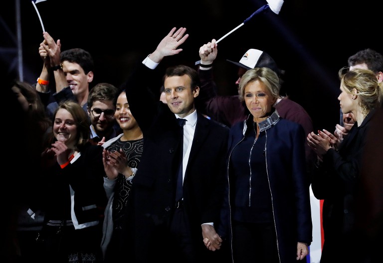 Emmanuel Macron, élu à la présidence de la République française, au centre, et son épouse Brigitte, devant la pyramide du Louvre, le 7 mai 2017. (Crédit : Patrick Kovarik/AFP)