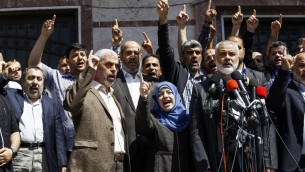Ismail Haniyeh, chef du groupe terroriste du Hamas, annonçant l'arrestation du tueur présumé de Mazen Foqaha, abattu le 24 mars 2017, près de sa maison dans la ville de Gaza, aux côtés de l'épouse de Foqaha et de Yahya Sinwar, chef du Hamas à Gaza, le 11 mai 2017. (Crédit : Mohammed Abed/AFP)