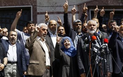 Ismail Haniyeh, chef du groupe terroriste du Hamas, annonçant l'arrestation du tueur présumé de Mazen Foqaha, abattu le 24 mars 2017, près de sa maison dans la ville de Gaza, aux côtés de l'épouse de Foqaha et de Yahya Sinwar, chef du Hamas à Gaza, le 11 mai 2017. (Crédit :  Mohammed Abed/AFP)