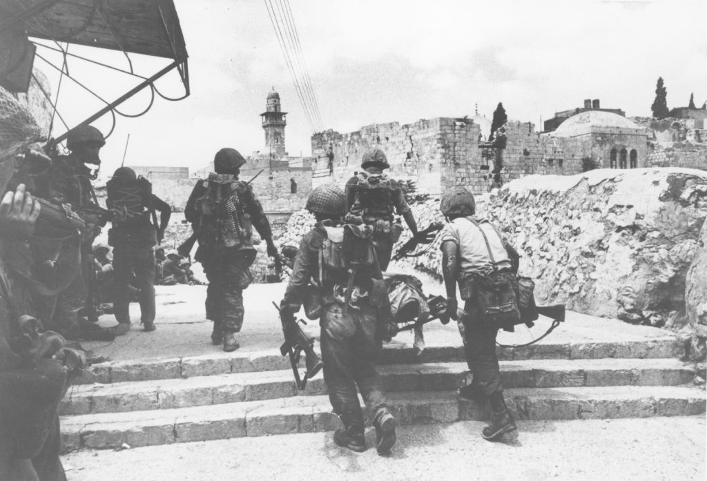 Les soldats emmenant un camarade blessé sur une civière dans les rues de la Vieille Ville de Jérusalem le 7 juin 1967. (Archives de l'armée israélienne du Ministère de la défense)