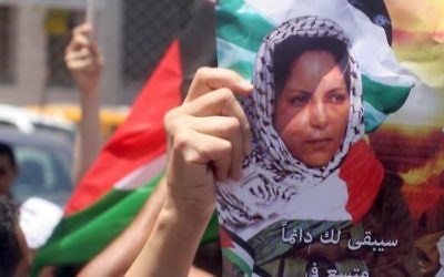 Des Palestiniens avec des affiches et des t-shirts représentant Dalal Mughrabi, une terroriste du Fatah responsable du massacre de la route côtière de 1978, qui a tué 38 Israéliens dont 13 enfants, pendant une manifestation à Ramallah, le 16 juillet 2008. (Crédit : Issam Rimawi/Flash90)
