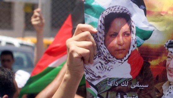 Des Palestiniens avec des affiches et des T-shirts représentant Dalal Mughrabi, une terroriste du Fatah responsable du massacre de la route côtière en 1978, qui a tué 38 Israéliens dont 13 enfants, pendant une manifestation à Ramallah, le 16 juillet 2008. (Crédit : Issam Rimawi/Flash90)
