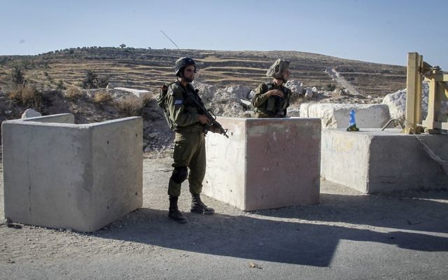 Des soldats à un poste de contrôle près de la ville de Hebron en Cisjordanie, le 2 juillet 2016. (Crédit : Wisam Hashlamoun / Flash90)