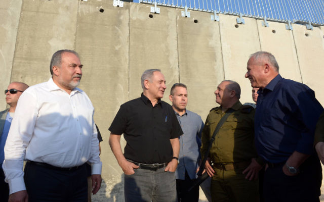 Le Premier ministre Benjamin Netanyahu et le ministre de la Défense Avigdor Liberman, avec le député Avi Dichter et le chef d'Etat-major Gadi Eizenkot, devant une nouvelle section de la barrière de sécurité entre Israël et la Cisjordanie, près de Tarqumiyah, le 20 juillet 2016. (Crédit : Haim Zach/GPO)