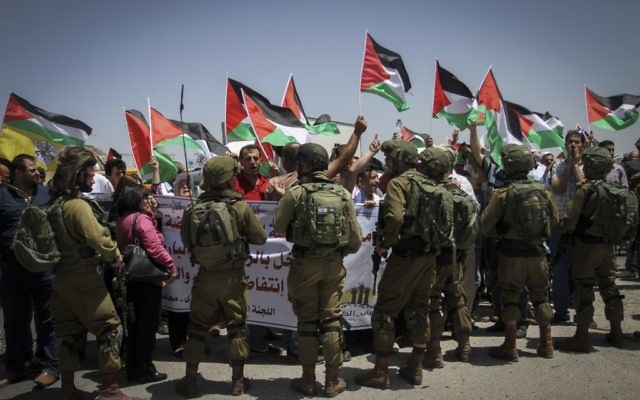 Soldats israéliens devant une manifestation palestinienne au checkpoint de Hawara, à Naplouse, en Cisjordanie, le 11 mai 2017. (Crédit : Nasser Ishtayeh/Flash90)