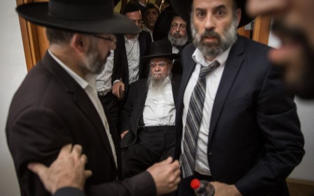 L'ancien grand rabbin séfarade Eliyahu Bakshi Doron, assis au centre, à son arrivée devant la cour du district de Jérusalem, entourés de ses soutiens qui tentent de cacher son visage, le 15 mai 2017. (Crédit : Hadas Parush/Flash90)