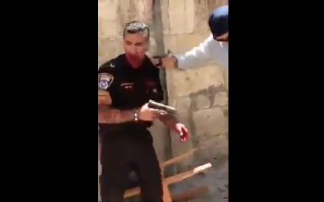 Une image de la séquence montrant un agent de police après qu'il a été poignardé par un agresseur, le samedi 13 mai, dans la Vieille ville de Jérusalem. La police a indiqué que l'agent a ensuite tiré sur l'attaquant, un Jordanien, qui est mort de ses blessures. Le policier a été hospitalité avec des blessures modérées (Capture d'écran : : Quds News Network/Twitter)