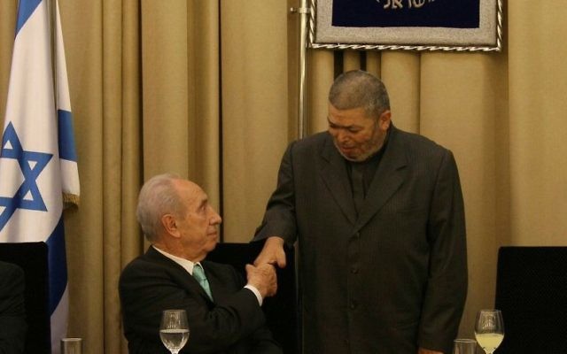 Feu le président israélien Shimon Peres échange une poignée de main avec Sheikh Abdullah Nimr Darwish, à droite, pendant un repas de l'Iftar à la résidence présidentielle de Jérusalem, le 9 septembre 2008 (Crédit :  Anna Kaplan/Flash90)