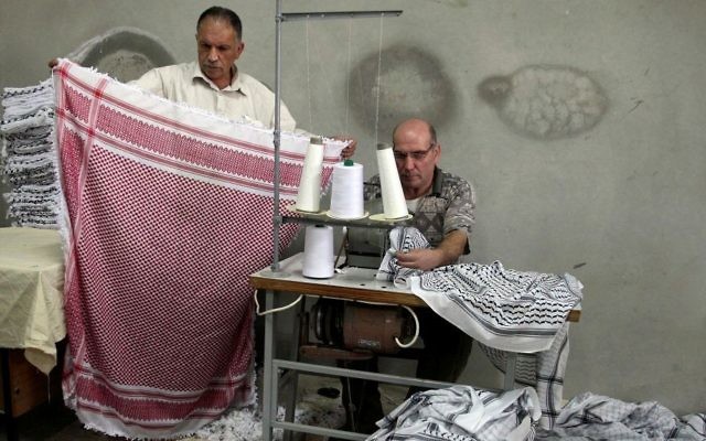 Des Palestiniens travaillent dans une fabrique de Keffieh, à Hébron, en Cisjordanie, le 14 octobre 2010. (Crédit : Najeh Hashlamoun/Flash90)