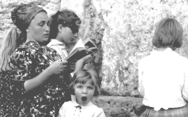 Une mère et ses filles prient au mur Occidental, pendant que la plus jeune baille, le 17 juin 1967. (Crédit : collection de Dan Hadani/Bibliothèque nationale d'Israël)