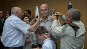 Le chef d'état-major de l'armée israélienne, Gadi Eizenkot, en train d'accrocher les galons de Muni Katz, qui a été promu général lors d'une cérémonie au quartier général de l'armée, Tel Aviv, le 11 mai 2017 (Crédit : Unité des porte-parole de l'armée israélienne)