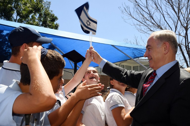 Le Premier ministre israélien Benjamin Netanyahu, à droite, salue les étudiants durant une visite au Moriah War Memorial College de Sydney,en Australie, le 23 février 2017 (Crédit : Dean Lewins/Pool/AFP)