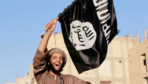 Un terroriste de l'État islamique brandissant le drapeau de l'organisation djihadiste. Illustration. (Crédit : Alatele fr/CC BY-SA/Flickr)