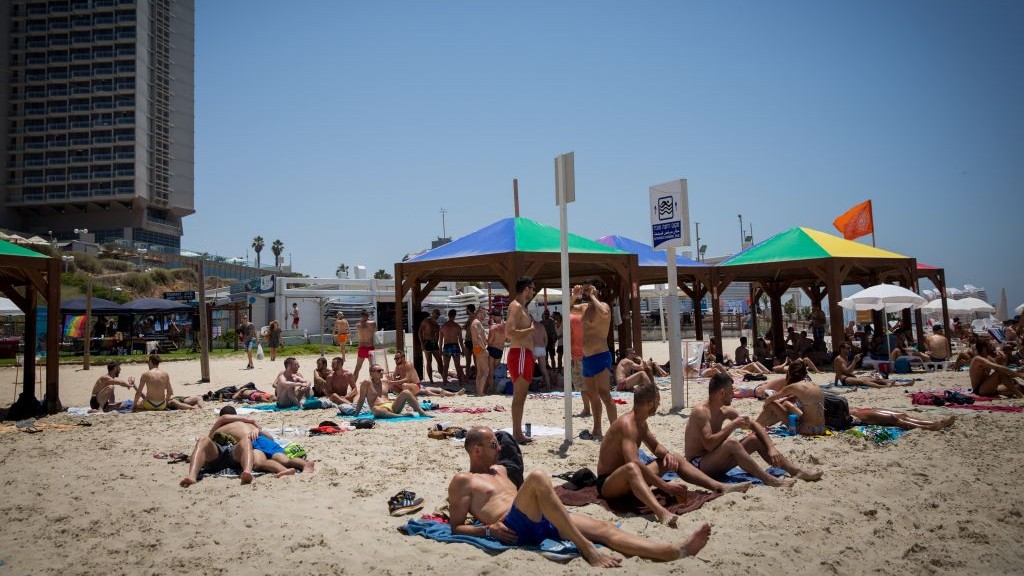 Des Israéliens et des touristes étrangers se prélassent sur une plage gay de Tel Aviv durant la semaine des fêtes des Fiertés de Tel Aviv , le 8 juin 2017. (Crédit : Miriam Alster/Flash90)
