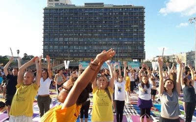 Des centaines de personnes sur la plus grande installation artistique en tapis de yoga au monde, illustrée par Amit Trainin pour représenter Israël en 2018, à l'occasion de la 3e Journée internationale du Yoga à Tel Aviv, le 21 juin 2017. (Crédit : Guy Mador/skylens)