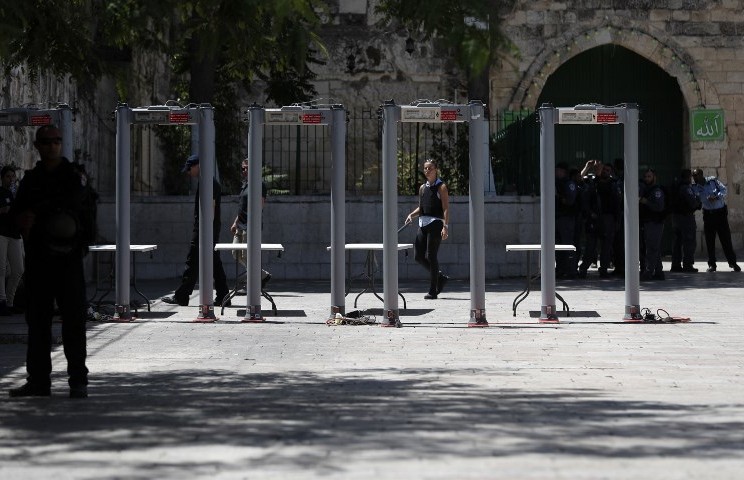 Des policiers israéliens installent des détecteurs de métaux aux abords de la Porte du Lion, entrée principale du mont du Temple, dans la Vieille ville de Jérusalem, après que les forces de sécurité ont rouvert ce lieu ultra-sensible qui avait été fermé après une attaque meurtrière la semaine dernière, suscitant la colère. Photo prise le 17 juillet 2017 (Crédit : AHMAD GHARABLI/AFP)