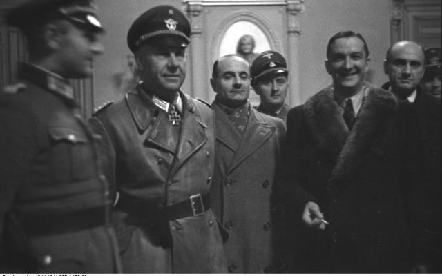René Bousquet (avec col de fourrure, le 2e en partant de la droite) entouré par, de gauche à droite, le SS-Sturmbannführer Bernhard Griese (en manteau de cuir), le préfet régional Antoine Lemoine, le chef local de la Sipo et du SD Rolf Mühler (de) (derrière Lemoine), l'administrateur de Marseille Pierre BarraudN 6, à l'hôtel de ville de Marseille le 23 janvier 1943, pendant la rafle de Marseille (Crédit : CC BY-SA 3.0 de)