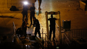 Les forces de sécurité israéliennes retirent des détecteurs de métaux à la Porte des Lions, près d'une entrée principale du mont du Temple dans la Vieille Ville de Jérusalem, le 24 juillet 2017. (Crédit : AFP / Ahmad GHARABLI)