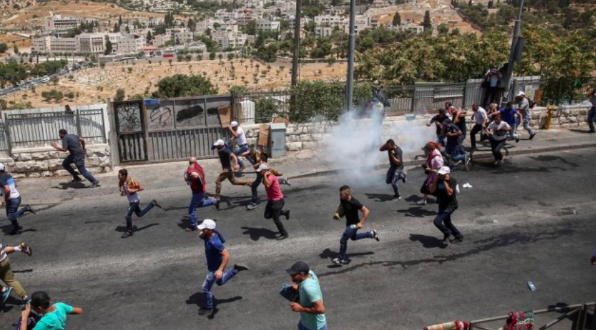 Des Palestiniens courent alors que la police israélienne émet des gaz lacrymogènes après les affrontements lors des prières du vendredi dans le quartier de Jérusalem-Est à Wadi al-Joz, le 28 juillet 2017 (Crédit : Miriam Alster / Flash90)