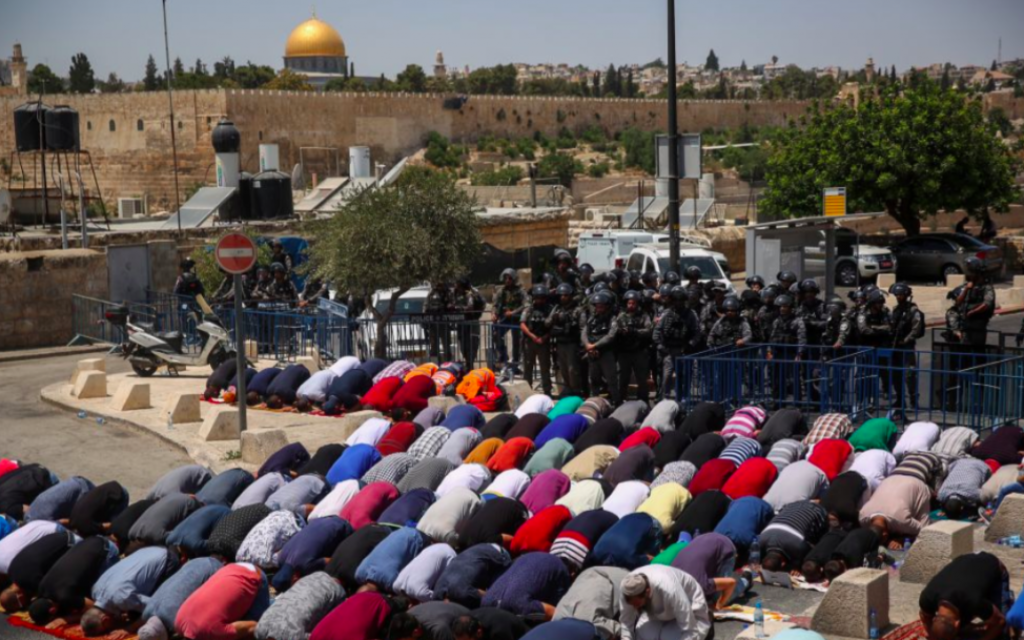 Les fidèles prient en dehors du mont du Temple sous l'oeil des forces de sécurité israéliennes, le 28 juillet 2017 (Crédit : Hadas Parush/Flash90)