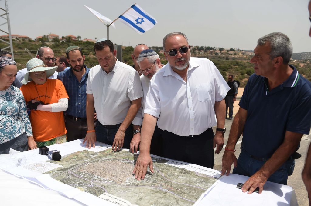 Le ministre de la Défense Avigdor Liberman présente son plan qui permettrait l'epansion de la ville de Qalqilya dans la zone actuellement contrôlée par Israël durant une visite dans l'implantation de Maale Shomron le 12 juillet 2017 (Crédit : Eden Moldavski/Defense Ministry)