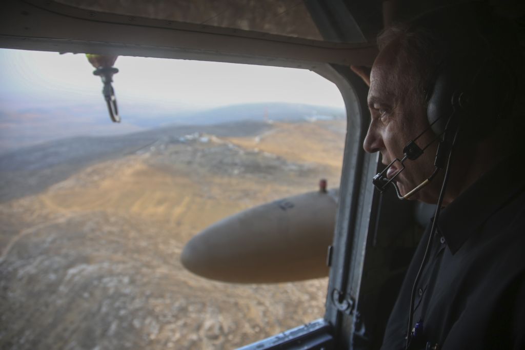 Le Premier ministre israélien Benjamin Netanyahu regarde la vue depuis un hélicoptère alors qu'il s'apprête à visiter la nouvelle barrière entre Israël et le territoire de Cisjordanie dans la zone de Tarqumiyah, le 20 juillet 2016 (Crédit :Marc Israel Sellem/POOL) 