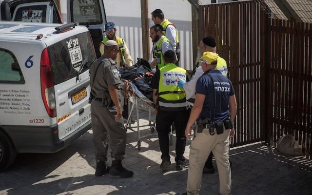 Le personnel médical israélien enlève le cadavre de l'un des terroristes impliqués dans un attentat à l'arme à feu à proximité du complexe du mont du Temple dans la Vieille ville de Jérusalem, le 14 juillet 2017 (Crédit : Hadas Parush/Flash90)