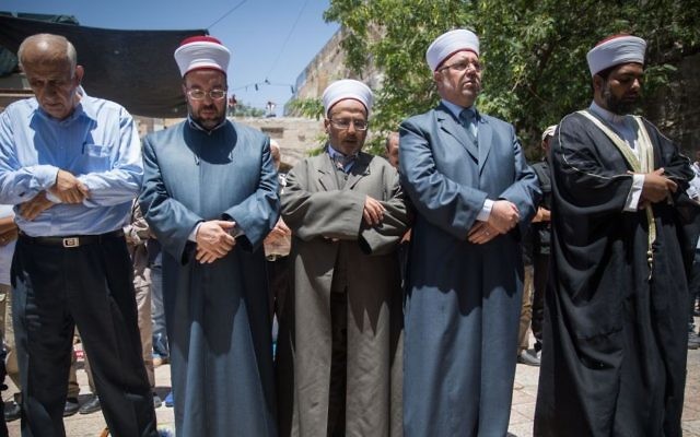 Des responsables du Waqf et des fidèles prêts à prier à l'extérieur du Mont du Temple plutôt que de passer par les détecteurs de métaux installés après un attentat, dans la Vieille Ville de Jérusalem, le 16 juillet 2017 (Crédit : Yonatan Sindel/Flash90)