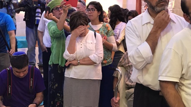 Les membres de la famille Salomon assistent à la circoncision de leur fils, Ari Yosef, dans la ville centrale d'Elad d'Israël, le 27 juillet 2017. (Crédit : Jacob Magid / Times of Israel)