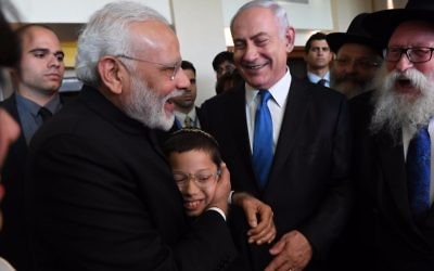 Moshe Holtzberg, le fils de deux émissaires du Habad tués dans un attentat en novembre 2008 à Bombay dans les bras du Premier ministre indien Narendra Modi, avec le Premier ministre Benjamin Netanyahu, en Israël, le 5 juillet 2017. (Crédit : Raphael Ahren/Times of Israël)