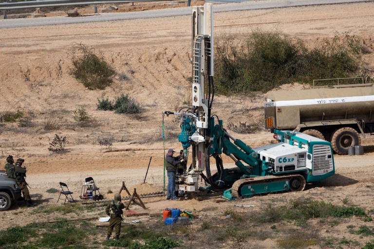 Cette photo datant du 10 février 2016 montre que les soldats de l'armée israélienne surveillent une machine qui forage pour creuser du côté israélien de la frontière avec la bande de Gaza alors qu'ils cherchent des tunnels utilisés par des terroristes palestiniens qui envisagent d'attaquer Israël (Crédit : AFP / Menahem Kahana)