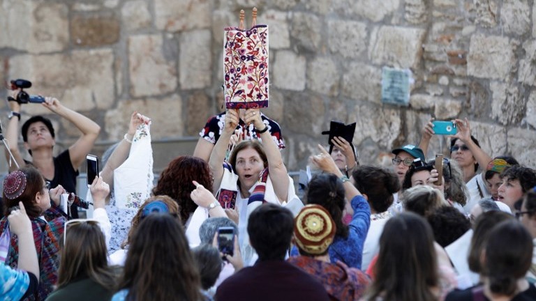 Les membres de l'association "Les femmes du mur" brandissent un rouleau de Torah durant un service de prière marquant le premier jour du mois juif d'Elul, au mur Occidental dans la Vieille Ville de Jérusalem, le 23 août 2017 (Crédit : Menahem Kahana/AFP)