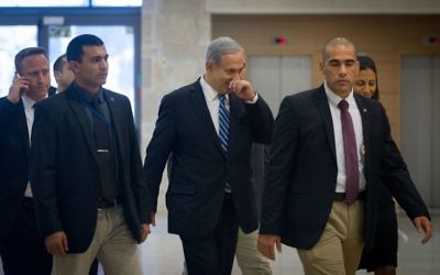 Le Premier ministre Benjamin Netanyahu, au centre, à la Knesset, suivi de son conseiller Ari Harow, à gauche au téléphone, le 8 décembre 2014. (Crédit : Miriam Alster/Flash90)