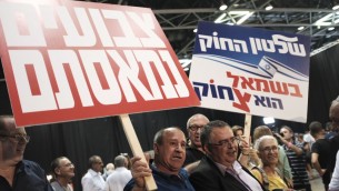 Des militants du Likud avec le député David Bitan, président de la coalition, au centre à droite, pendant un rassemblement de soutien au Premier ministre Benjamin Netanyahu, à Tel Aviv, le 9 août 2017. (Crédit : Tomer Neuberg/Flash90)
