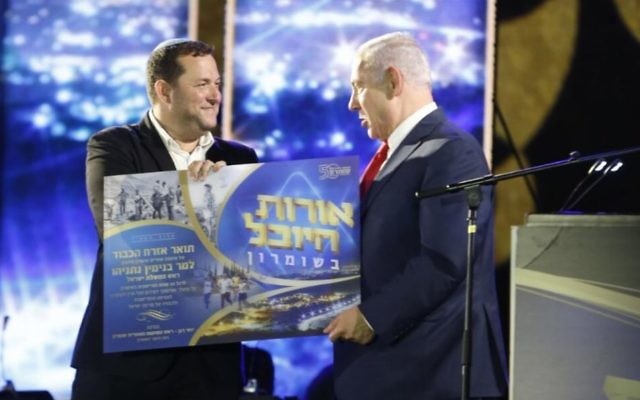 Le Premier ministre Benjamin Netanyahu, à droite, avec Yossi Dagan, leader du mouvement des implantations, lors d'un événement commémorant  50 années d'implantation en Cisjordanie, le 28 août 2017. (Crédit : Jacob Magid/Times of Israël)