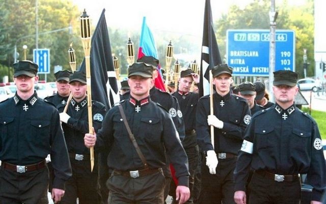 Un groupe d'extrême droite slovaque défilant à Bratislava avec leur ancien chef Marian Kotleba (au centre, en avant plan) parés d'uniformes néonazis noirs en 2016, en Slovaquie (Crédit : Matúš Tremko/Creative Commons Attribution-Share Alike 4.0 International/Wikimedia)