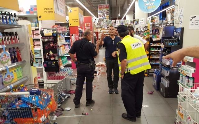 La police et les médecins sur les lieux d'une attaque dans un supermarché de la ville israélienne de Yavne, le 2 août 2017 (Crédit : United Hatzalah)
