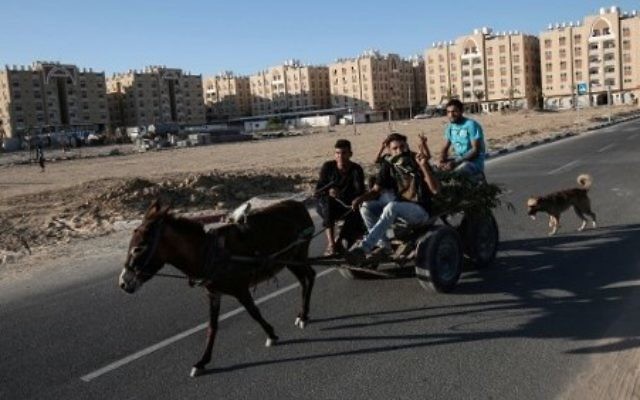 Des Palestiniens dans une charrette tirée par un âne dans des zones résidentielles financées par le Qatar à  Khan Younis dans le sud de la bande de Gaza, le 6 juin 2017. (Crédit : AFP/Said Khatib)