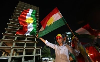 Kurdes irakiens avec leurs drapeaux pendant une manifestation appelant le peuple à voter au référendum d'indépendance, à Erbil, la capitale de la région autonome du Kurdistan irakien, le 22 septembre 2017. (Crédit : Safin Hamed/AFP)