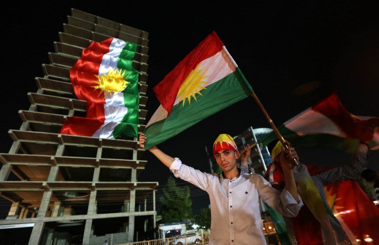 Kurdes irakiens avec leurs drapeaux pendant une manifestation appelant le peuple à voter au référendum d'indépendance, à Erbil, la capitale de la région autonome du Kurdistan irakien, le 22 septembre 2017. (Crédit : Safin Hamed/AFP)